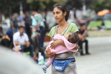 Syrian refugee woman with child in Belgrade clipart
