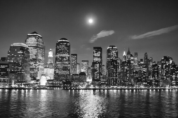 The Manhattan Financial District viewed from the New York Harbor at night in New York City, USA.