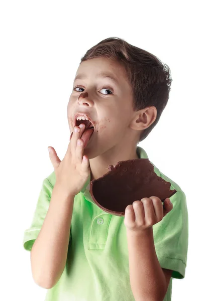 Malý chlapec jíst čokoládové velikonoční vajíčko na bílém pozadí — Stock fotografie