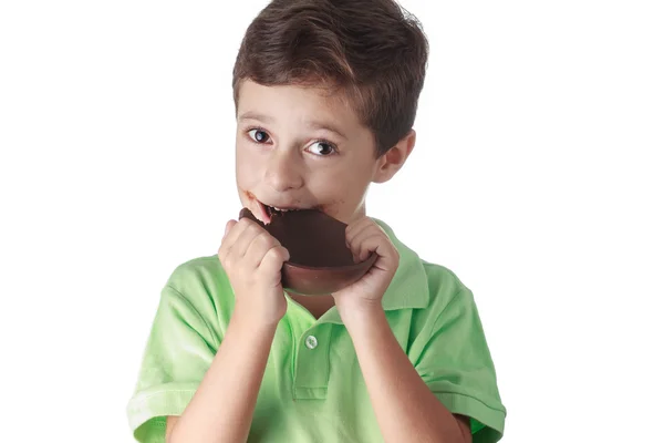 Piccolo ragazzo mangiare cioccolato uovo di Pasqua su sfondo bianco — Foto Stock