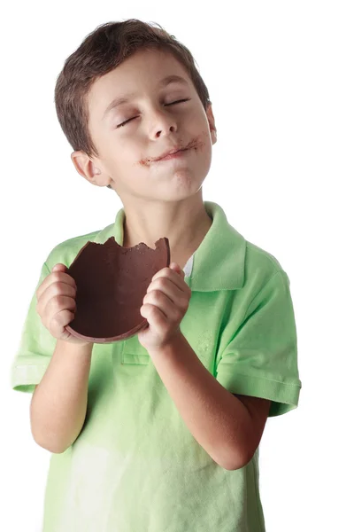 Niño comiendo huevo de Pascua de chocolate sobre fondo blanco —  Fotos de Stock