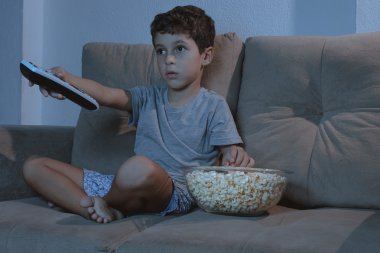 Kanepede televizyon izlerken ve patlamış mısır geceleri yemek küçük çocuk ben