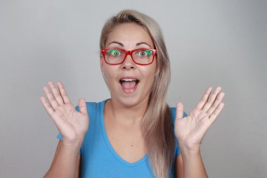 Gri arka plan üzerinde kırmızı gözlük sürpriz sarışın kadın