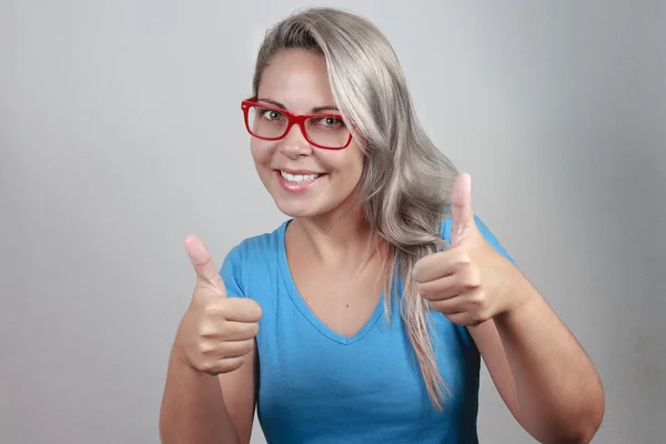 Feliz hermosa chica en elegantes gafas rojas mostrando el pulgar hacia arriba —  Fotos de Stock