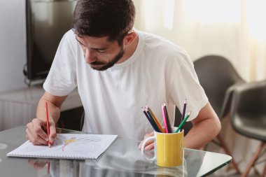 Bir yetişkin renklendirme renklendirme bir masada oturan bir adam portresi 