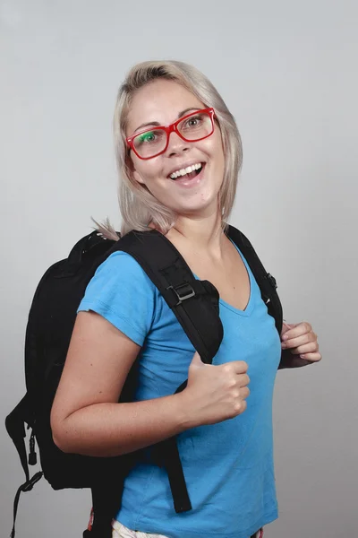 Jonge blonde schoolmeisje met rode bril en schooltas — Stockfoto