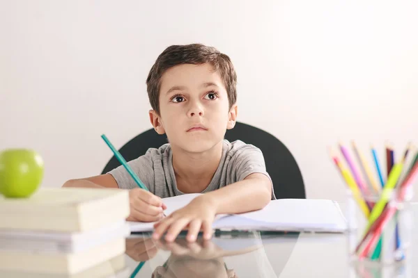 Откровенный портрет мальчика, делающего домашнее задание и занимающегося дома — стоковое фото
