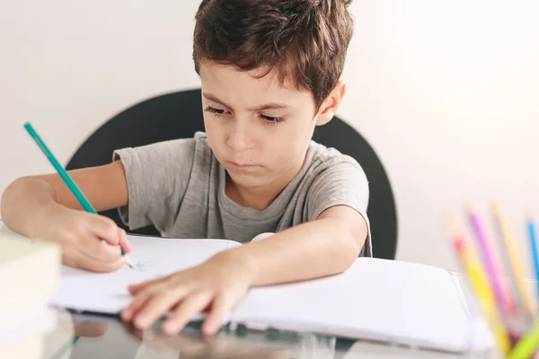 Candid portrait of a boy doing his homework and studying at home — Stock Photo, Image