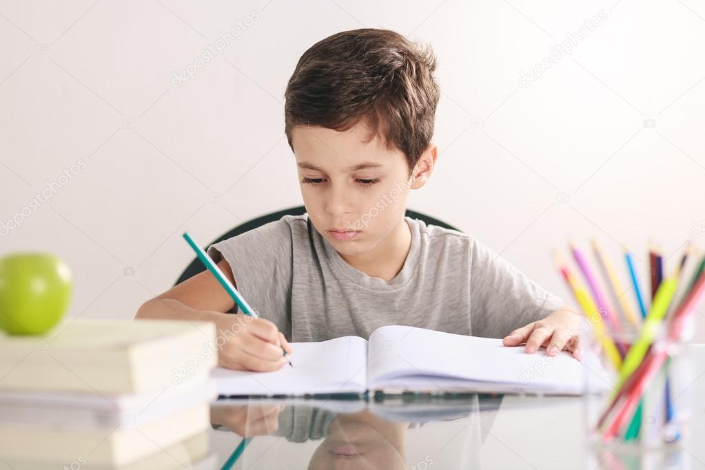 Candid portrait of a boy doing his homework and studying at home