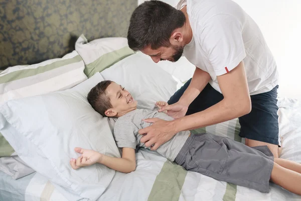 Ayah menggelitik anaknya di tempat tidur — Stok Foto