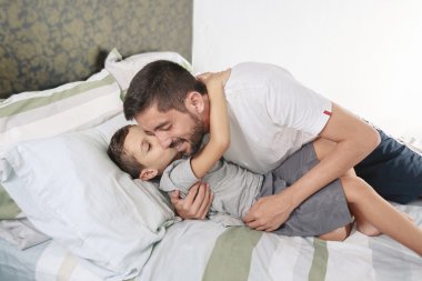 Genç çocuk babası yatakta öpüşme