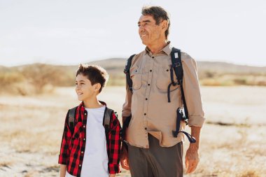 Sırt çantalı Latin büyükbaba ve torun dağlarda yürüyüş yapıyor..