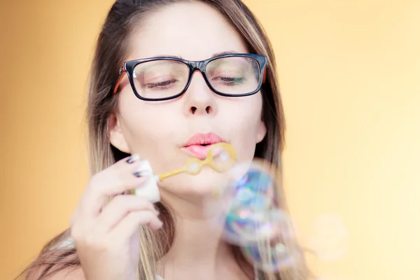 Mooie jonge vrouw blazen van zeepbellen buitenshuis — Stockfoto
