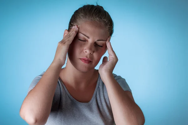 Traurige Frau hält den Kopf wegen Kopfschmerzen — Stockfoto