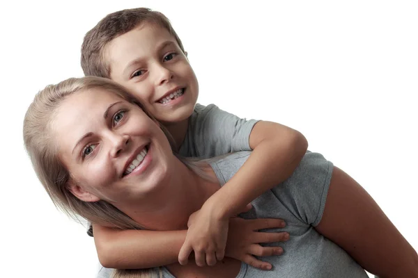 Son hugging his mother from behind and she smiling isolated on w Stock Image