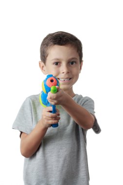Küçük çocuk üzerinde beyaz izole plastik su tabancası ile oynarken.