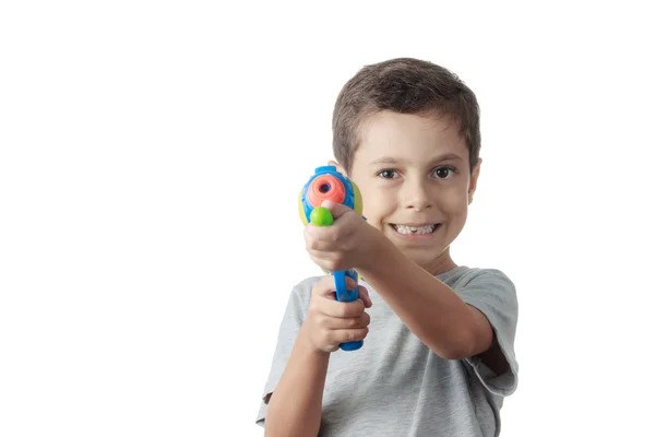 Menino brincando com arma de água de plástico isolado no branco . — Fotografia de Stock