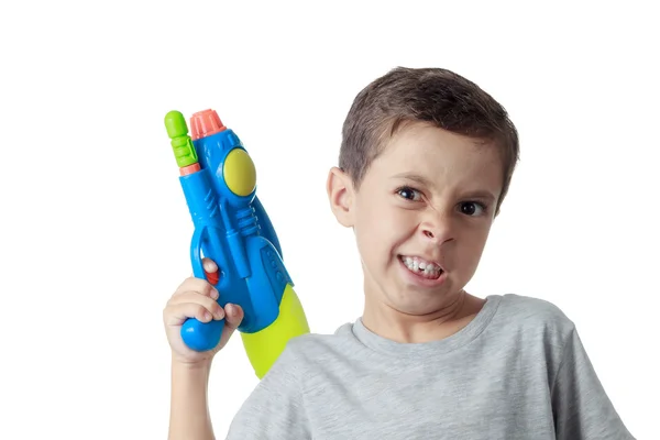 Menino com expressão engraçada brincando com arma de água de plástico — Fotografia de Stock