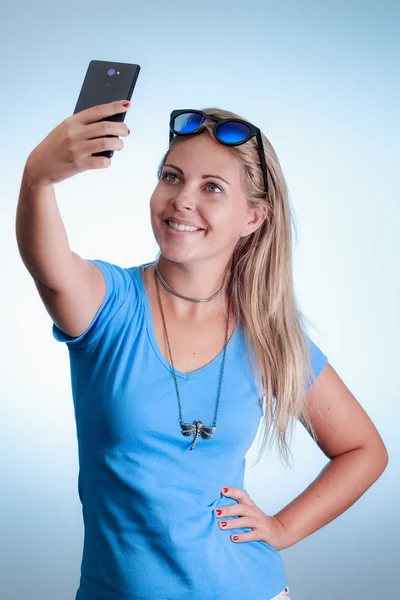 Mujer tomando autorretrato con smartphone. El uso de una camisa azul —  Fotos de Stock