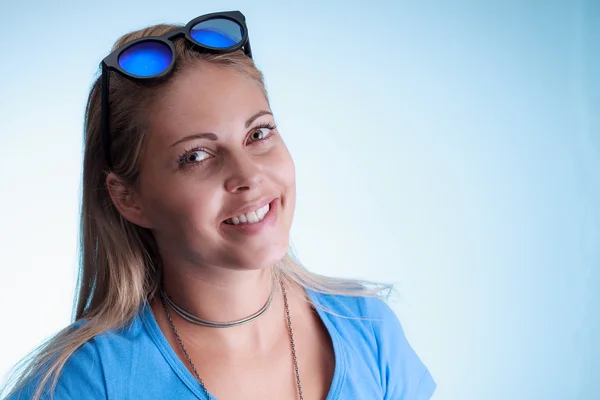 Hermosa mujer sonriente con gafas de sol azules sobre su cabeza —  Fotos de Stock