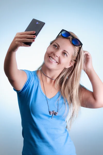 Mujer tomando autorretrato con smartphone. El uso de una camisa azul —  Fotos de Stock