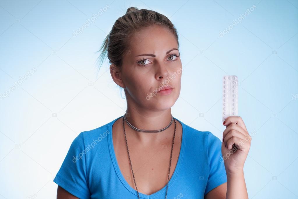 Woman with serious expression showing a blister medication. Birt