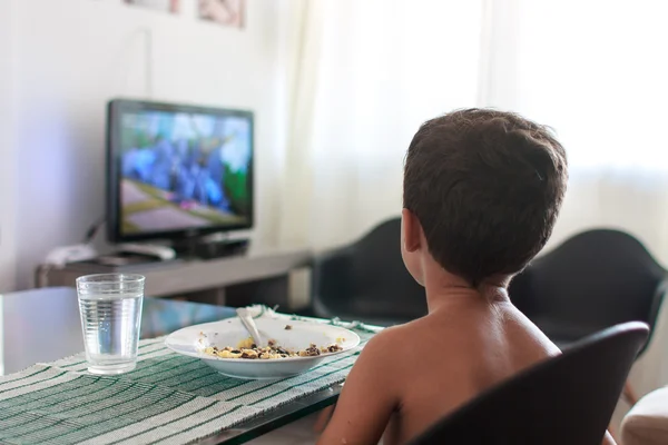 Anak terganggu menonton tv makan siang — Stok Foto