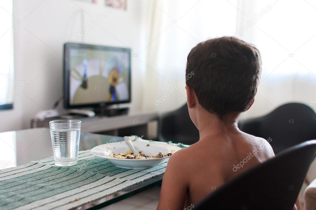 Child distracted watching tv eating lunch