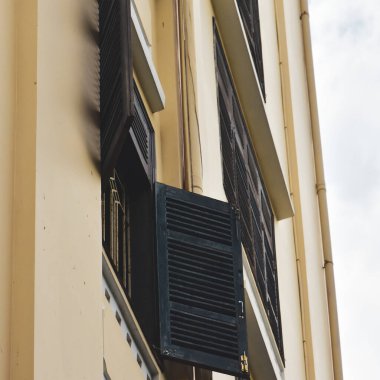 Bir sıra eski kahverengi yıpranmış pencere farı. Beyaz ahşap panjurlu pencere. Arkaplan olarak antik ahşap pencereler