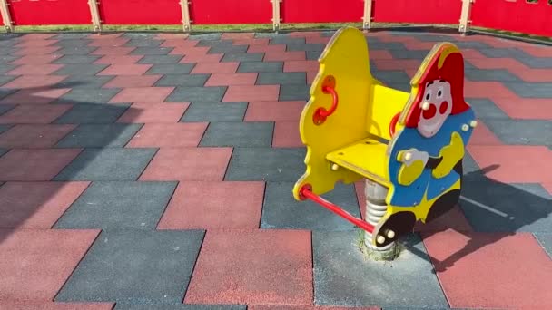ゴム製のカバーで遊び場の消防士の形をした子供の春のスイング — ストック動画