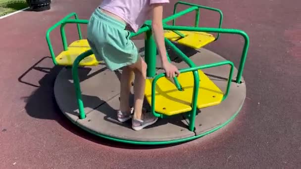 Mädchen Kurzen Hosen Auf Einem Karussell Auf Dem Spielplatz — Stockvideo