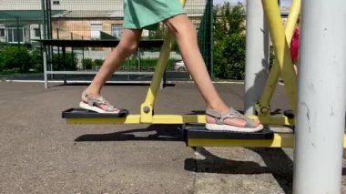 Kız bacak eğitmenine egzersiz yaptırıyor, koşuyor, yürüyor, adım atıyor. Bacaklarını kapat. 