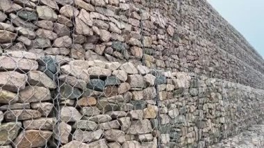 Çelik tel örgü sepetinden yapılmış Gabion duvarı. Taş duvarlar, kıyı aşınmasından korunma. Gabion ve Rock zırh-kıyı ve su yolları koruması