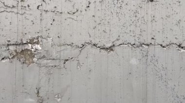 Çatlaklarla, deliklerle ve diğer kusurlarla boyanmış beton duvarlar. Yakın plan görüntüle  