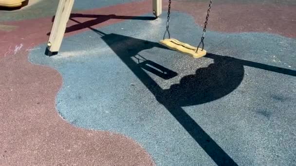 子供の遊び場で空の黄色のチェーンスイング — ストック動画