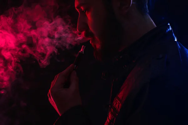 Bebaarde stijlvolle man houden en elektronische sigaret roken — Stockfoto