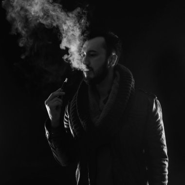 Sakallı şık adam tutarak ve elektronik sigara