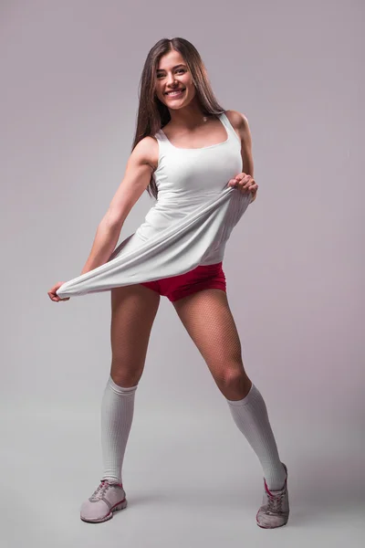 studio portrait of a young beautiful sporty woman, wearing   sports shorts