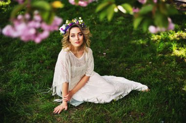 Uzun kırmızı üfleme saç açık havada bahar güzellik kız. Çiçek açan sakura ağacı. Romantik genç kadın portre