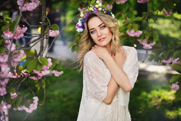 Vårens skönhet flicka med långa röda blåser håret utomhus. Blommande sakura träd. Romantiska ung kvinna porträtt — Stockfoto