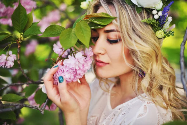 Vårens skönhet flicka med långa röda blåser håret utomhus. Blommande sakura träd. Romantiska ung kvinna porträtt — Stockfoto