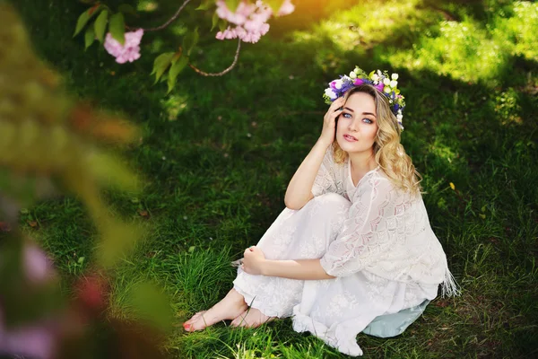 Spring beauty meisje met lange rode haren buiten waait. Bloeiende sakura boom. Romantische jonge vrouw portret — Stockfoto