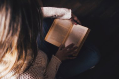 Kitap okuma oturma odasında pencere rahatlatıcı yakınındaki genç kadın evde oturan 