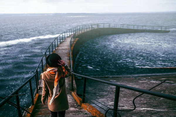 Mujer joven mirando las montañas sobre el mar, viento de freedo — Foto de Stock