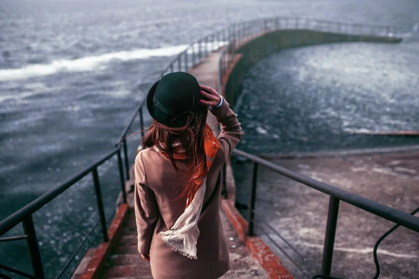 Mujer joven mirando las montañas sobre el mar, viento de freedo — Foto de Stock