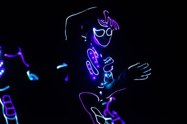 dansçılar renkli koyu arka plan üzerinde led elbiseli göster 