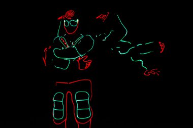 dansçılar mürettebat koyu arka plan, renkli gösteri üzerinde led elbiseli