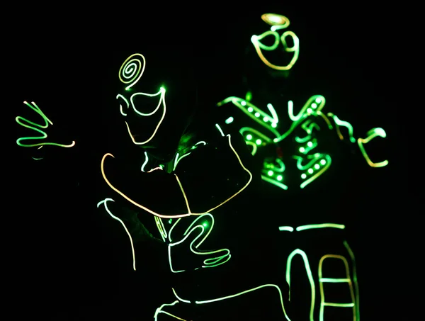 Dançarinos tripulação em ternos led no fundo escuro, show colorido — Fotografia de Stock