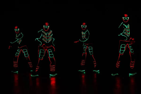 Zespół tańca w strojach z diod LED — Zdjęcie stockowe