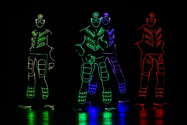 Танцевальная команда в костюмах светодиодов, светлых костюмах — стоковое фото